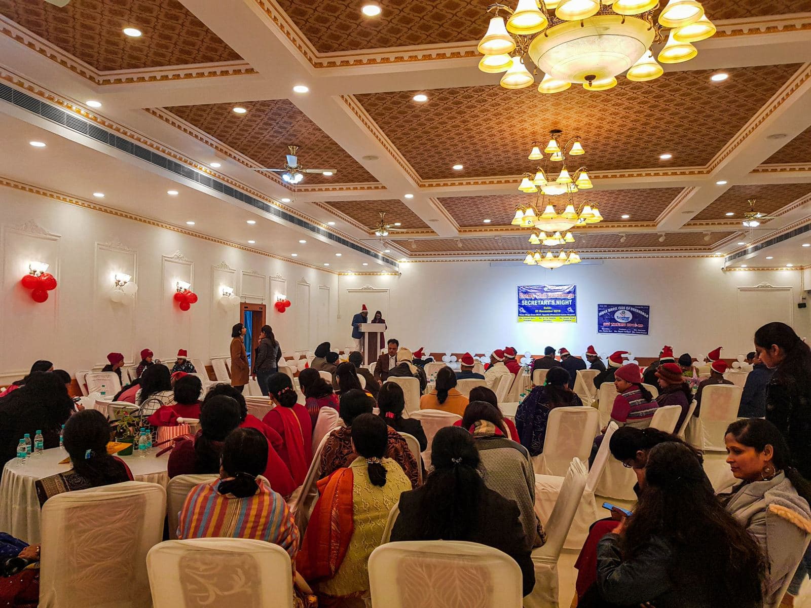 Banquet hall with chandeliers and guests seated at round tables